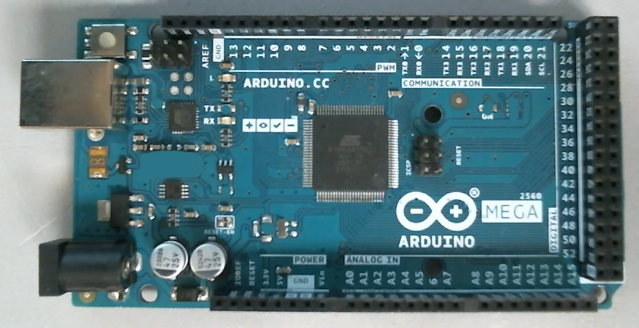 The same board with four parts lifted by hand: the 16 MHz crystal at centre left, the TX and ON indicator LEDs, and one more part below them. The defects the inspector is asked to find are physical, not simulated.